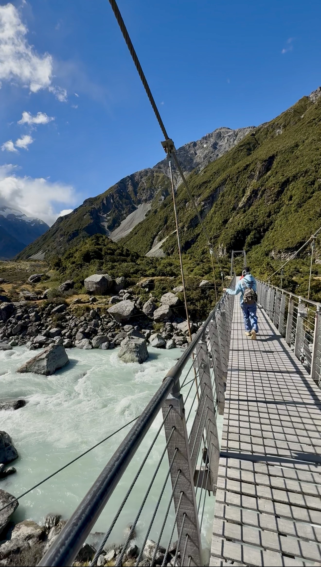 Suspension bridge over blue green water Hooker Valley Track New Zealand