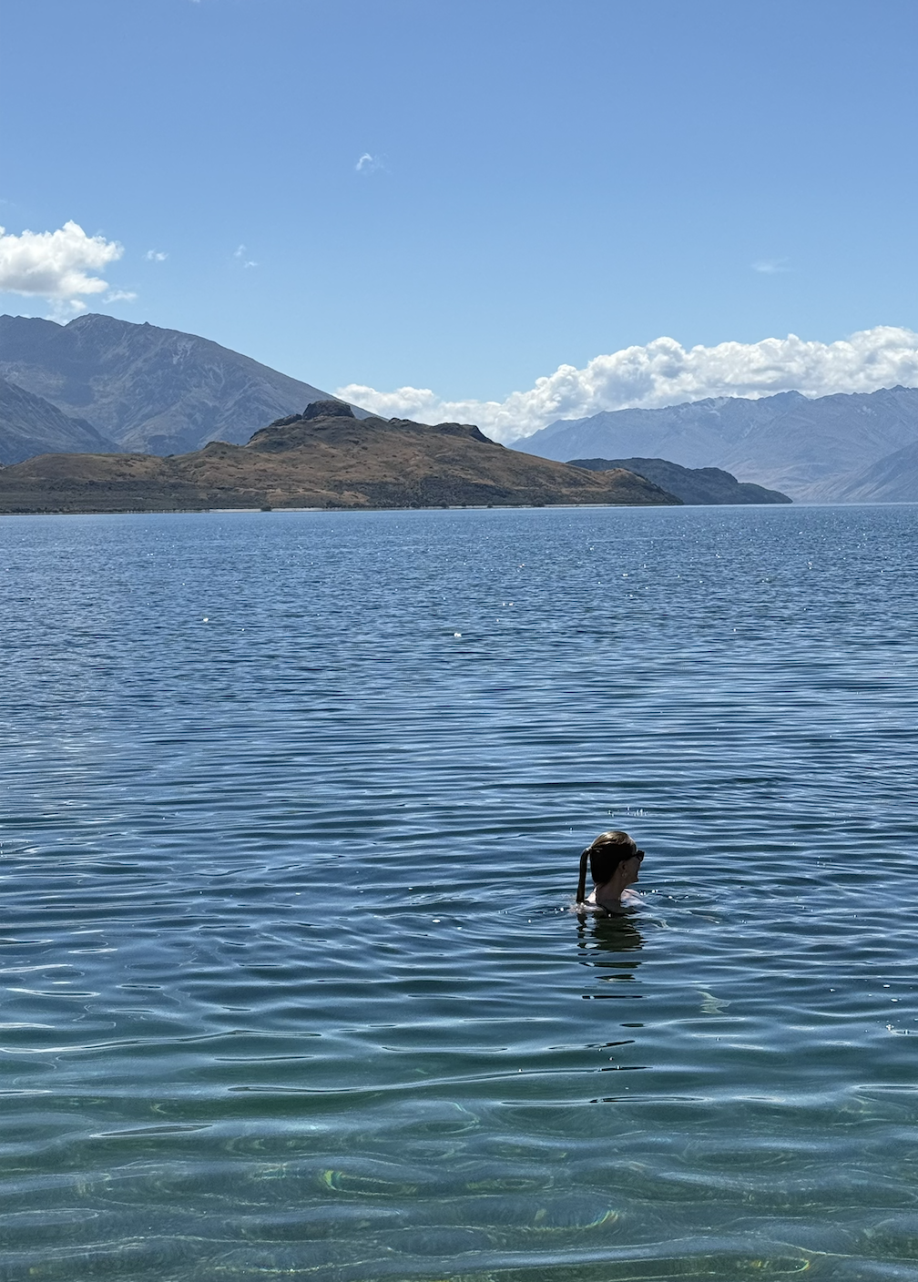 woman swimming in lake wanaka in new zealand
