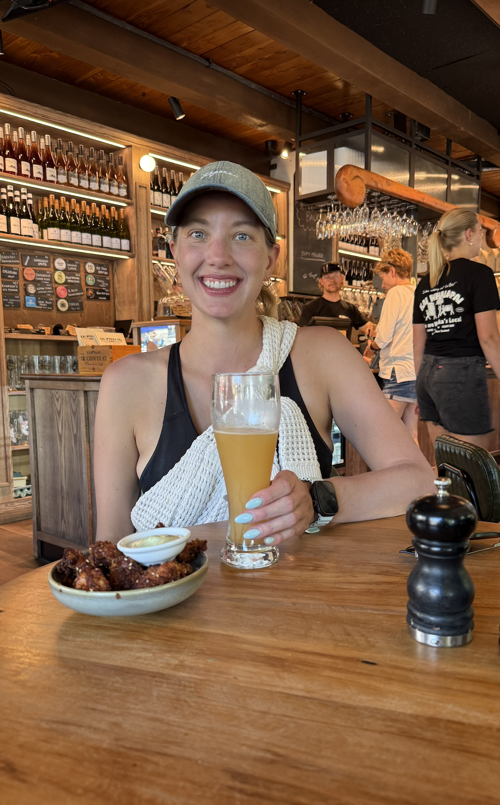 Woman drinking beer at lake front restaurant in Wanaka New Zealand