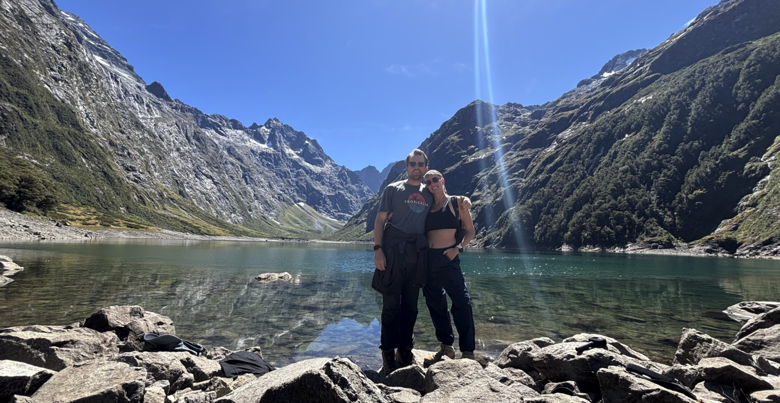 Couple in front of clear blue alpine Lake Marion New Zealand