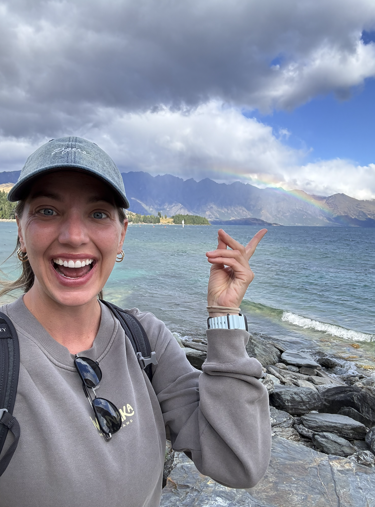Girl with rainbow over water in Queenstown New Zealand