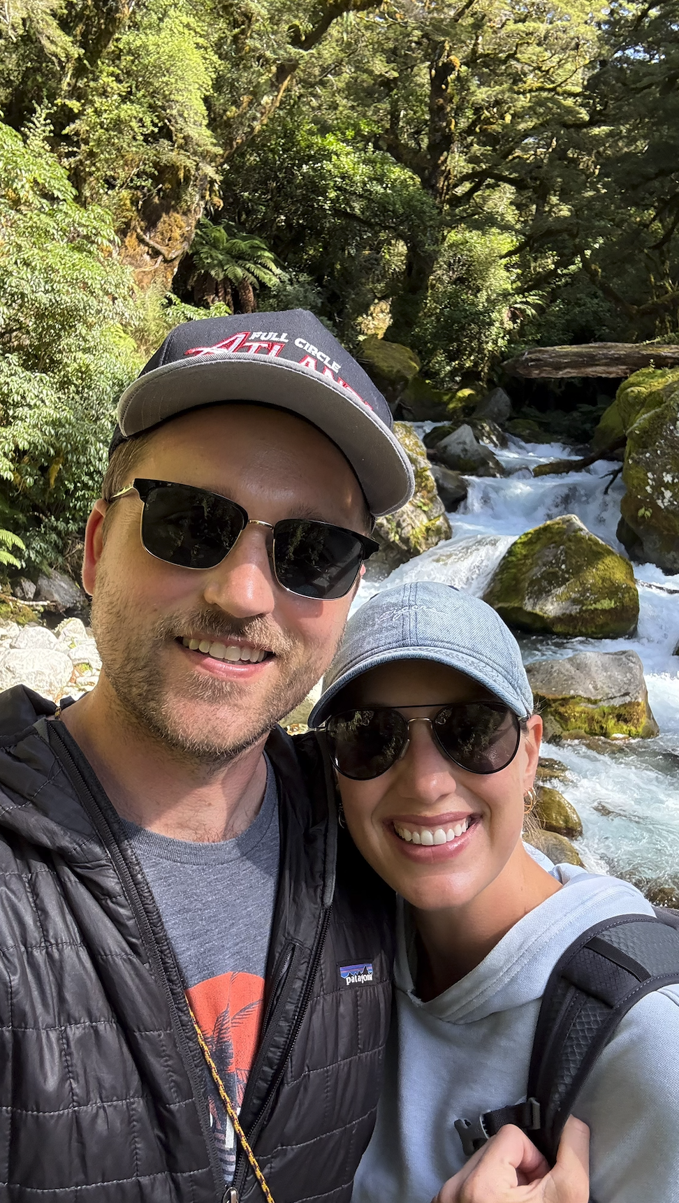 Couple in front of waterfall on Lake Marion track in Fiordland National Park New Zealand