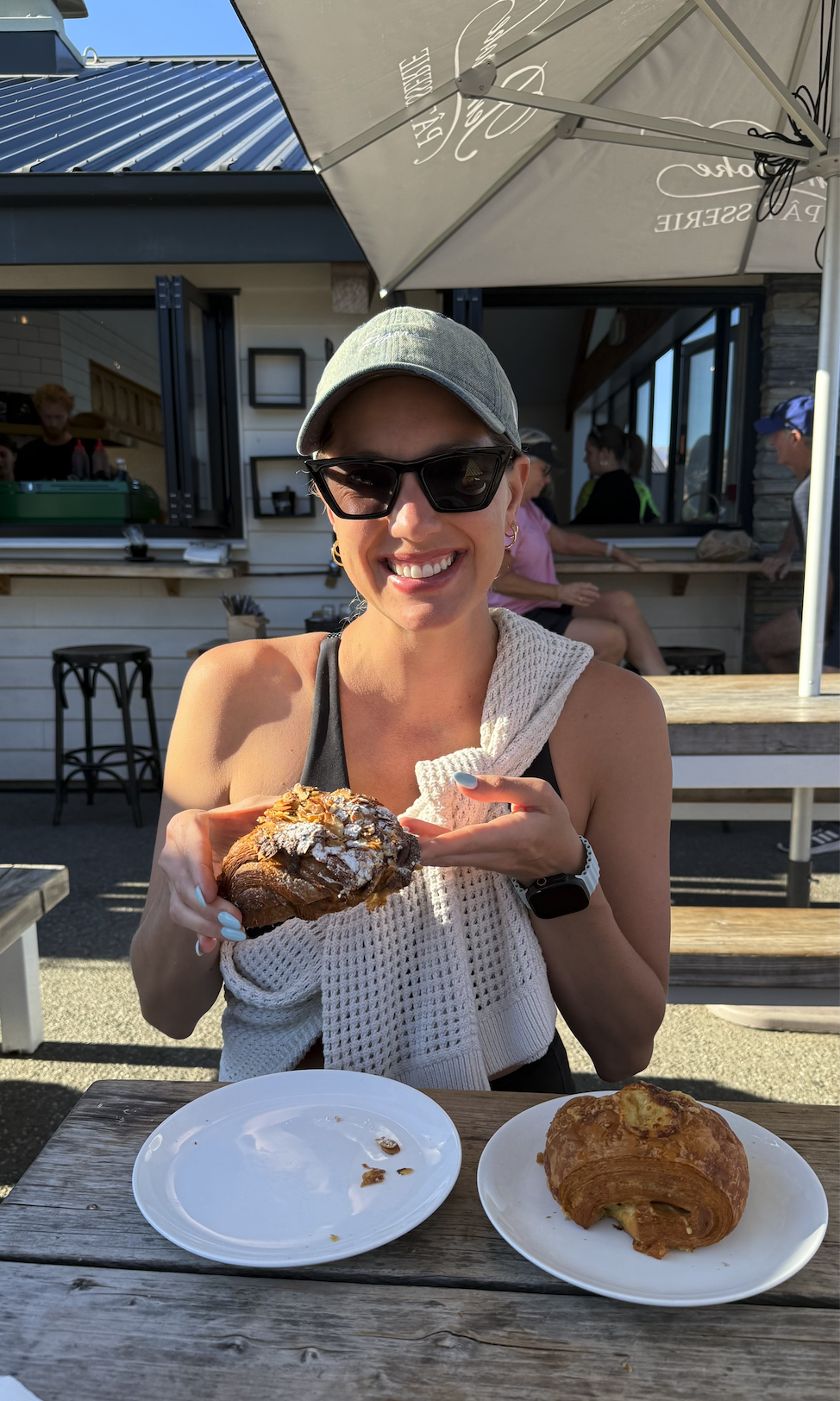 Woman holding up croissant at Pembrooke Patisserie in Wanaka New Zealand
