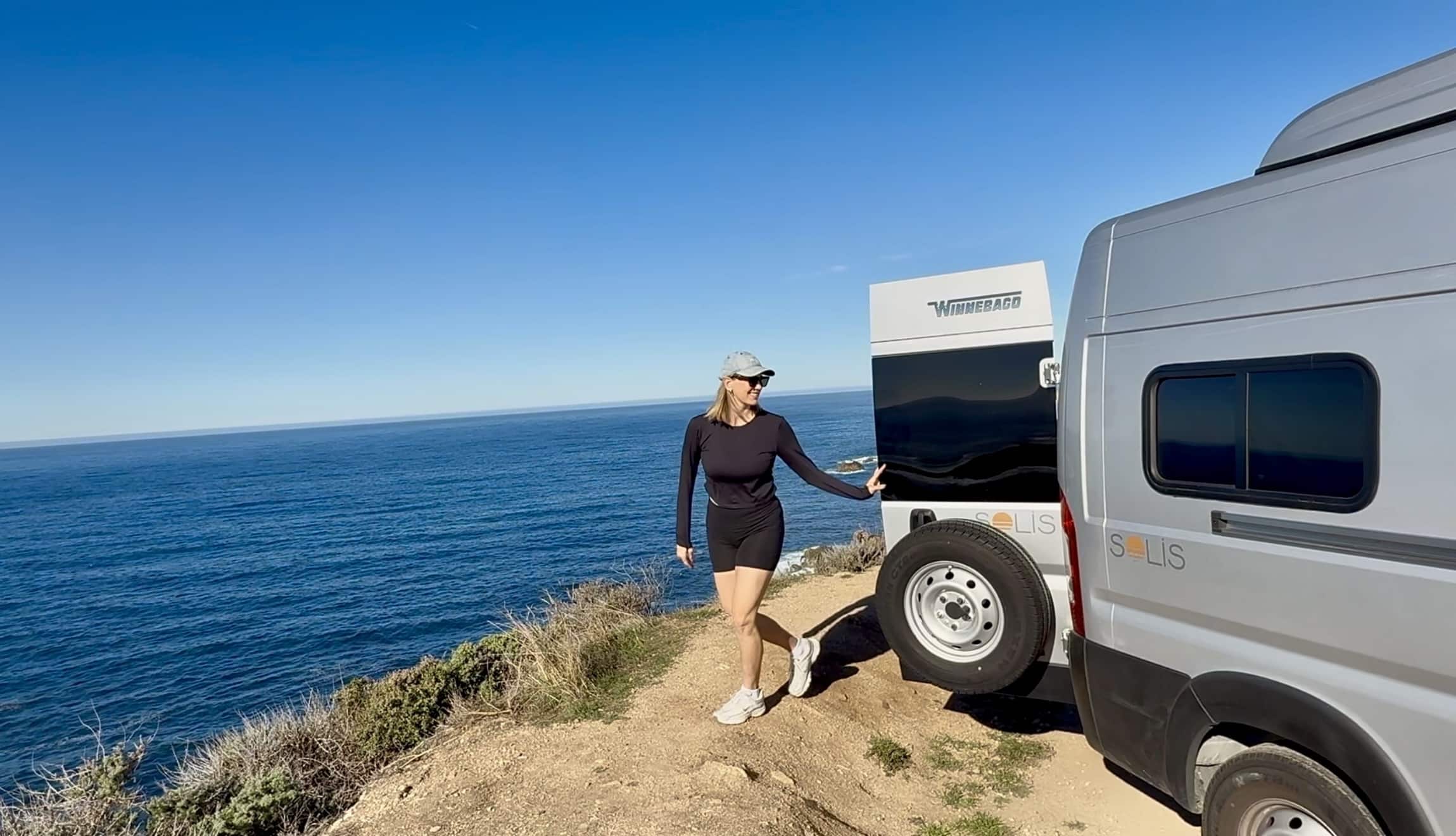 woman with campervan on bluff over ocean on Highway 1 Pacific Coast Highway Big Sur California